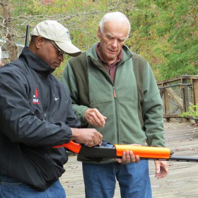 An instructor teaching safe firearms handling to a workshop participant.